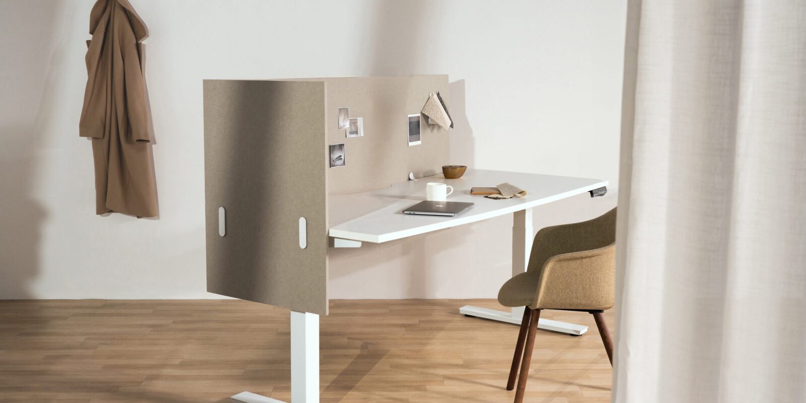 A photo of a desk with acoustic screens attached to the left hand side and back side.