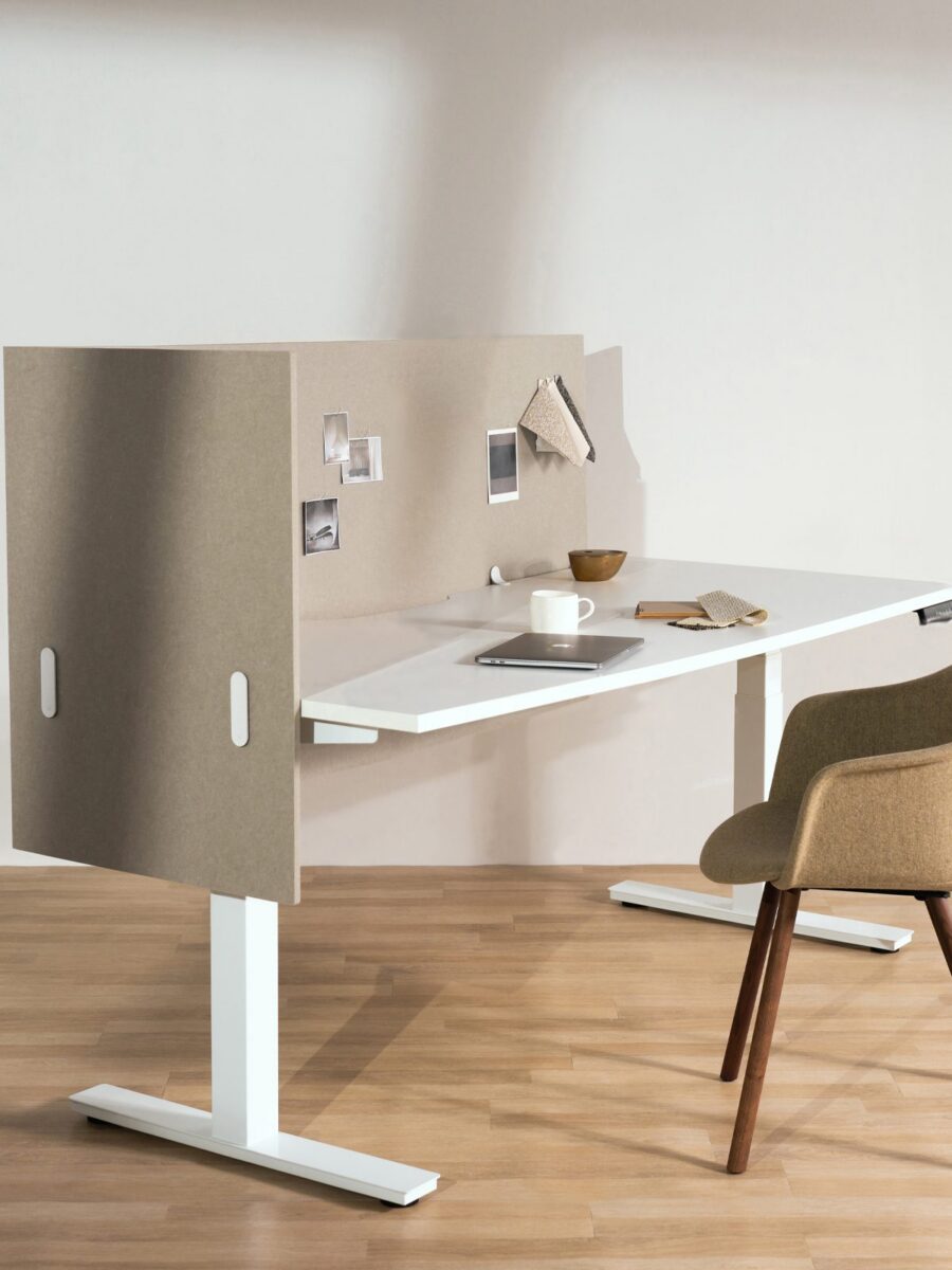 A photo of a desk with acoustic screens attached to the left hand side and back side.